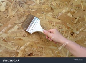manos pintando panel osb con brocha