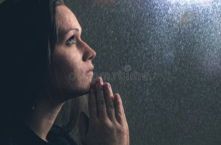 manos rezando bajo lluvia intensa