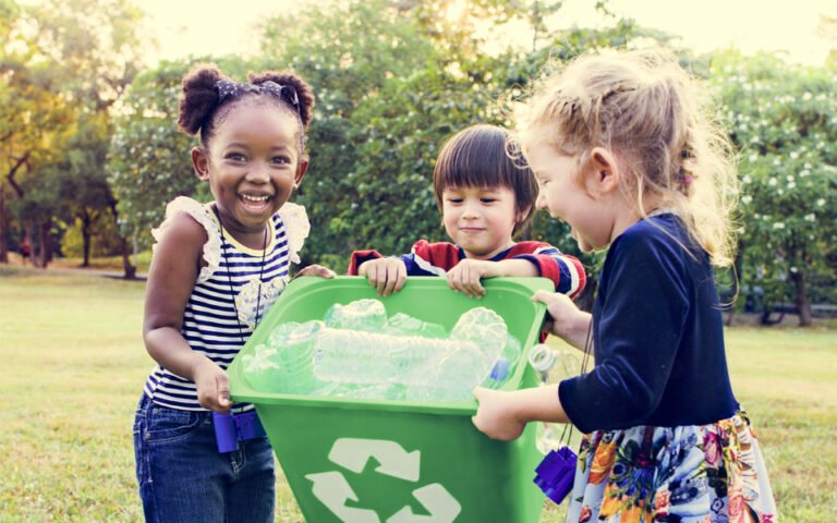 ninos reciclando con contenedores de colores